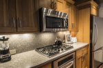 Fully equipped kitchen has stainless steel appliances and granite counters